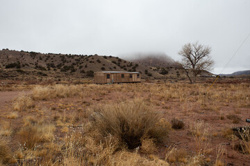 Abandoned mobile home in middle of high desert on overcast day