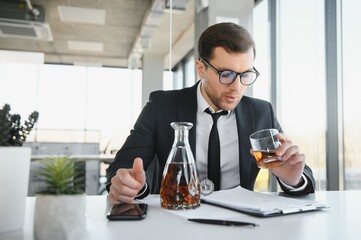 Businessman drinking from stress at workplace