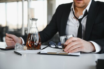 Fototapeta premium Businessman drinking from stress at workplace