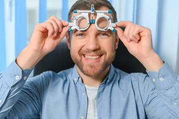 Handsome man getting an eye exam at ophthalmology clinic. Checking retina of a male eye close-up