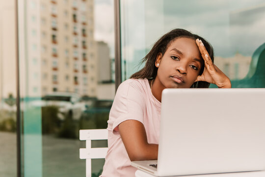 Tired exhausted overworked african american woman hipster sitting outside with laptop. Young entrepreneur freelancer student businesswoman low energy need to sleep have a rest chill
