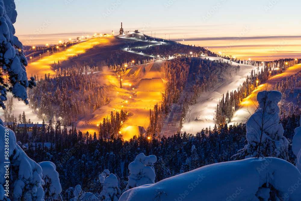 Wall mural A high angle view to Ruka ski resort slopes on a late winter evening near Kuusamo, Northern Finland