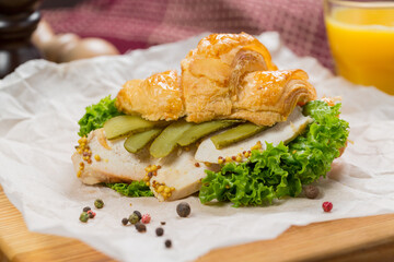 Croissant sandwich with chicken, cheese, cucumber.