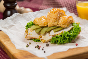 Croissant sandwich with chicken, cheese, cucumber.