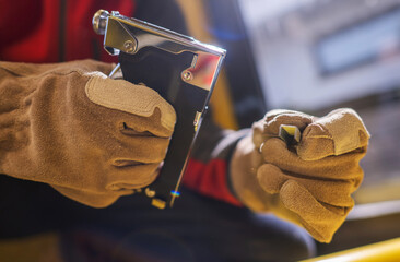 Heavy Duty Staple and Brad Tacker in Contractor Hands. General Construction Tools Theme.