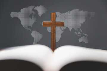 Cross with open Holy Bible on table with world map blur background. mission evangelism and gospel...