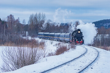 Retro steam train moves at winter time.