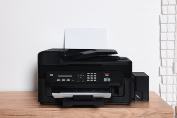 Fototapeta premium Modern printer with paper on wooden table indoors