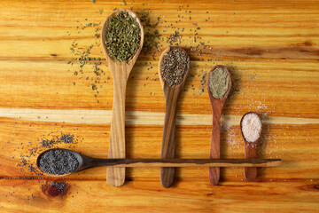 Guayacan wood background and wooden spoons with condiments