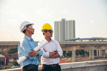 Two men engineer look at blueprint architecture building contractor design in modern city...