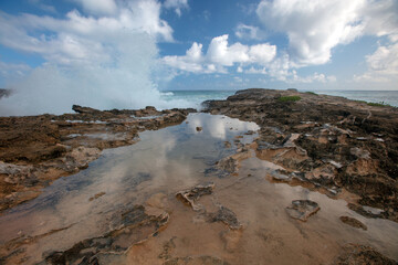 Cloud reflections and storm waves crashing into Laie Point coastline at Kaawa on the North Shore of Oahu Hawaii United States