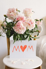 Happy Mothers Day. Fresh peonys and postcard for mom on white background. Stylish greeting card. Greeting card template with text