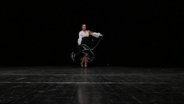 Young woman gracefully performs Spanish flamenco dance in slow motion