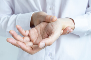 Hand of man she massages his thumb and has finger pain, locked finger from work and office syndrome. on a white background medical concept