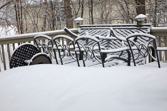 New snowfall covering everything and creating patterns and texture on patio furniture near Minneapolis Minnesota