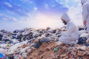 Scientists with coverall suit, investigated and inspected garbage pile in landfill. An environment...