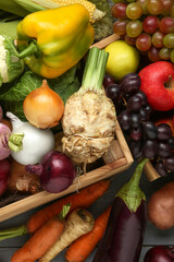 Different fresh vegetables and fruits with crate on grey wooden table, top view. Farmer harvesting