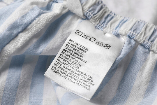 Clothing label on beautiful striped garment, closeup