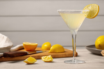 Lemon Martini cocktail and fresh fruits on white wooden table, space for text