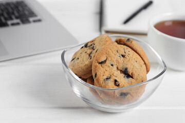 Chocolate chip cookies on white wooden table in office, closeup