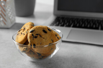 Chocolate chip cookies on light gray table at workplace. Space for text