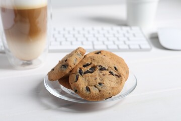 Chocolate chip cookies on white wooden table at workplace
