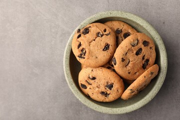 Delicious chocolate chip cookies on grey table, top view. Space for text