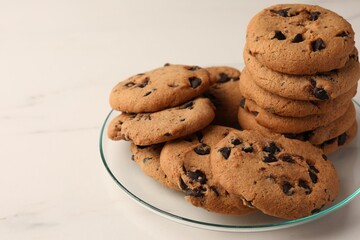 Delicious chocolate chip cookies on white marble table, closeup. Space for text