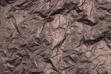 Crumpled black plastic bag as background, top view