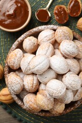 Bowl of delicious nut shaped cookies on wooden table, flat lay