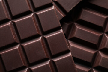 Many delicious dark chocolate bars as background, top view