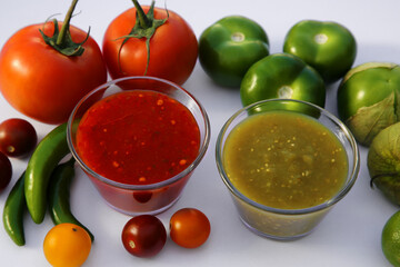Bowls with delicious salsa sauces and ingredients on white background, closeup