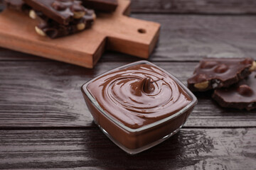Bowl with tasty chocolate paste on wooden table