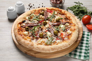 Tasty pizza with anchovies and ingredients on grey wooden table