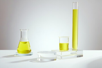 Laboratory concept with erlenmeyer flask, beaker and test tube containing yellow liquid and empty...