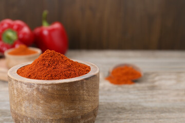Bowl with aromatic paprika powder on table, closeup. Space for text