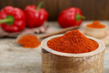 Bowl with aromatic paprika powder on table, closeup. Space for text