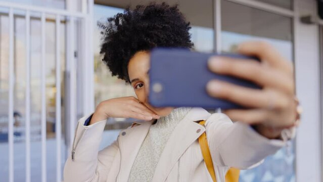 Woman, kiss selfie and afro in city with smile, blog post or video call on urban adventure with internet. Girl, metro and freedom with photography, profile picture and influencer on social media app