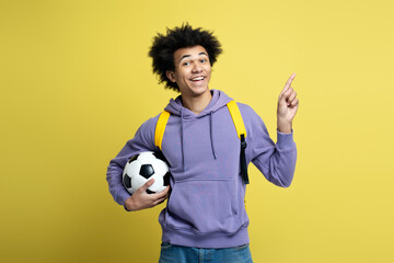 Portrait of young smiling African American man holding ball for soccer game