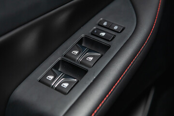 Side door buttons: window, mirror adjustment buttons, door lock. Car inside.