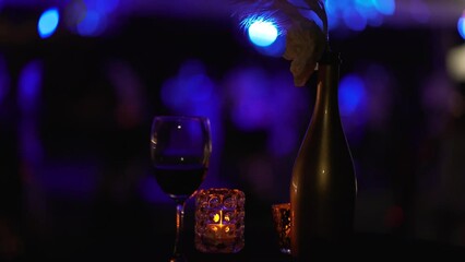 A glass of red wine placed on the wooden table with candle lighting as background. Generative Ai image.
