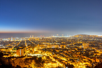 The skyline of Barcelona with the Mediterranean Sea in the back at night