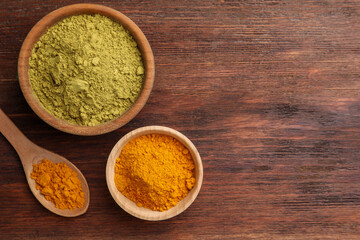 Henna and turmeric powder on wooden table, flat lay. Space for text