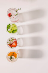 Top view of ribbed glasses with lemonade or infused water with different flavors - obrazy, fototapety, plakaty