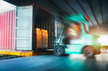 Blurred Forklift Tractor Loading Package Boxes into Cargo Container. Shipment Boxes. Delivery to Customers. Supplies Warehouse. Freight Truck Logistics Transport 	
