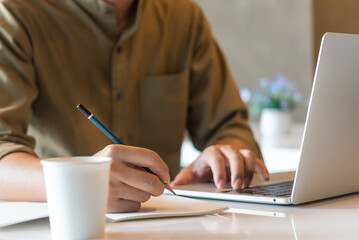 hand man writing notes workspace using a computer. communication and information management. education, business, or creative business concept.