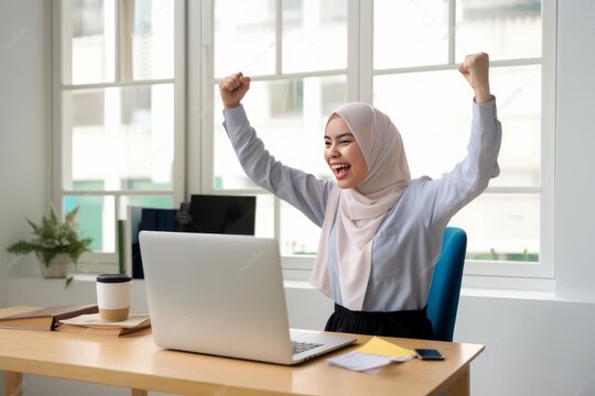A woman in a hijab is celebrating her success with her laptop. Generative AI