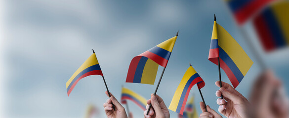 A group of people holding small flags of the Colombia in their hands
