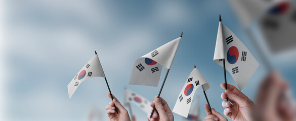Fototapeta na wymiar A group of people holding small flags of the South Korean in their hands