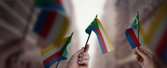 A group of people holding small flags of the Comoros in their hands